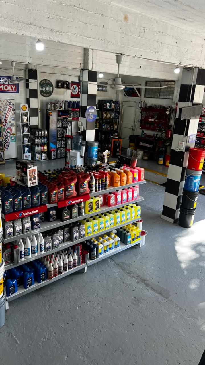 Interior del local con productos Castrol, Total y más